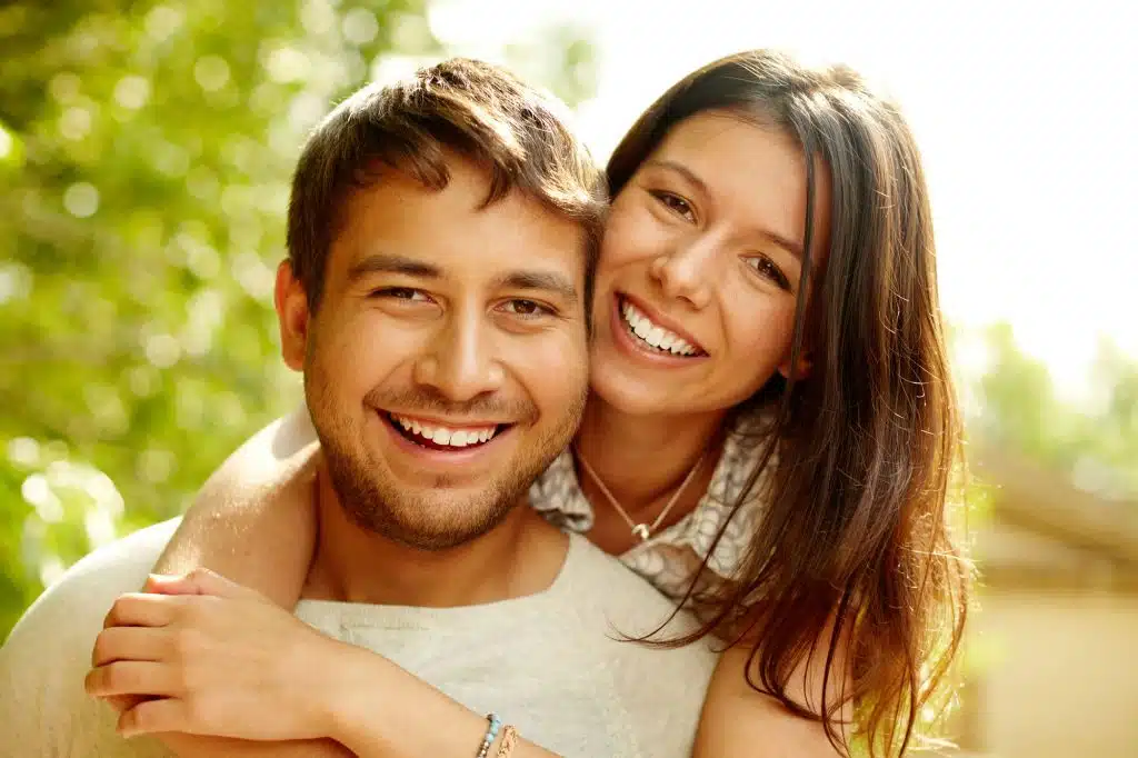 Smiling adult couple with straight teeth